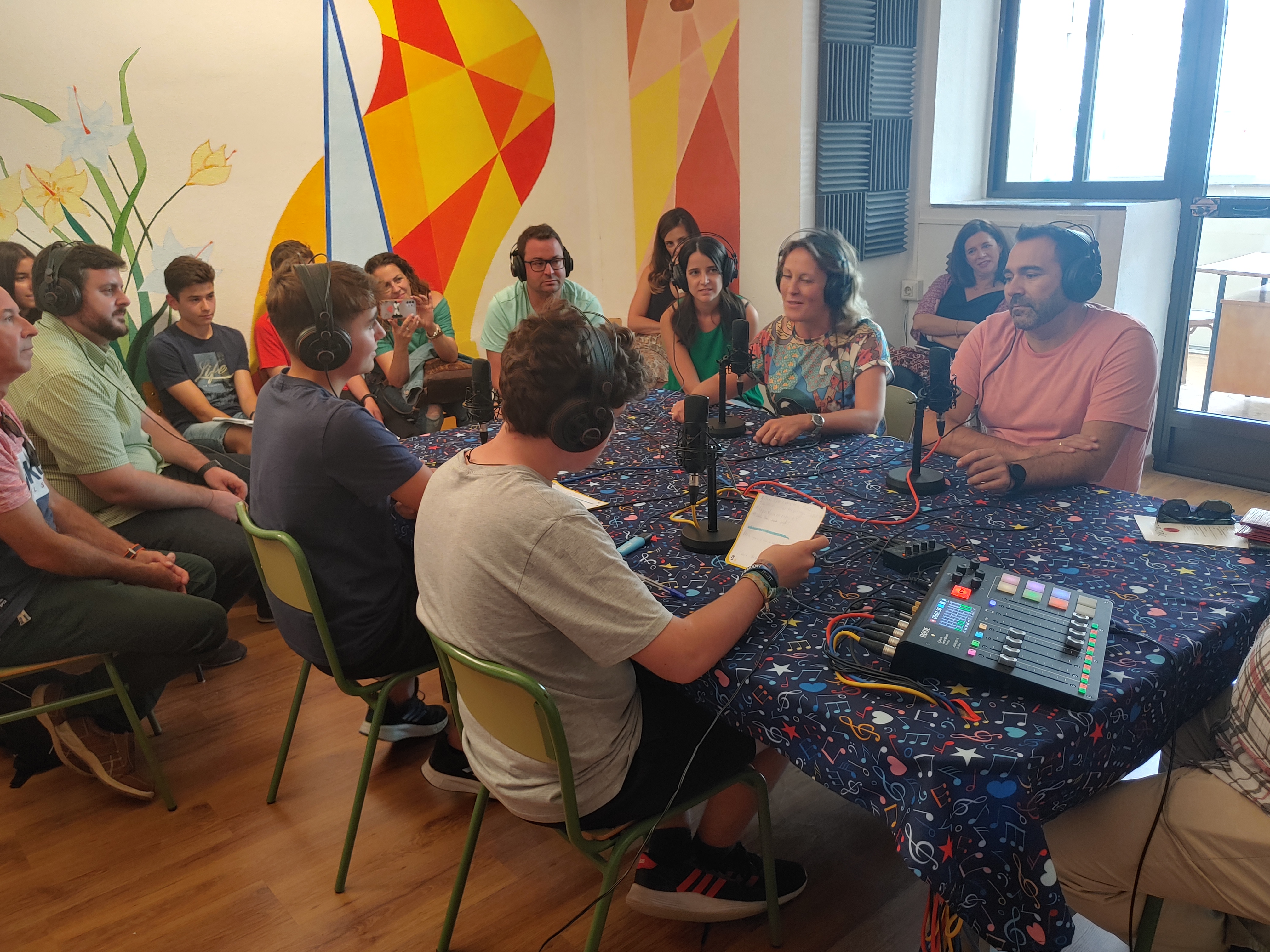 Participantes de Escolapios en la Onda grabando alrededor de los micrófonos del estudio